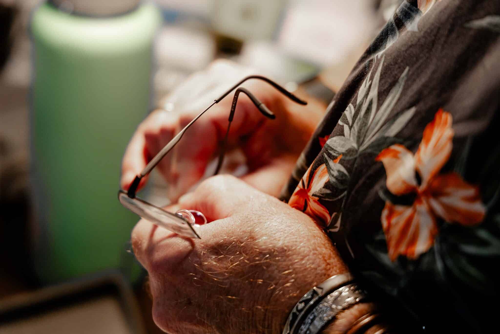 Close-up of glasses being adjusted by hand